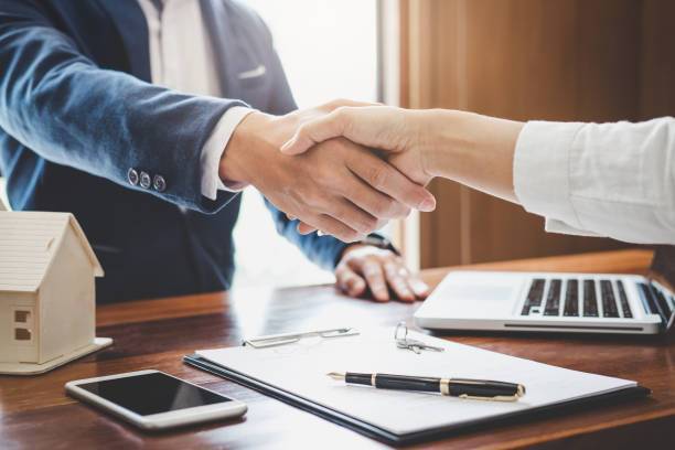 finance-broker-melbourne - Real estate agent and customers shaking hands together celebrating finished contract after about home insurance and investment loan, handshake and successful deal.